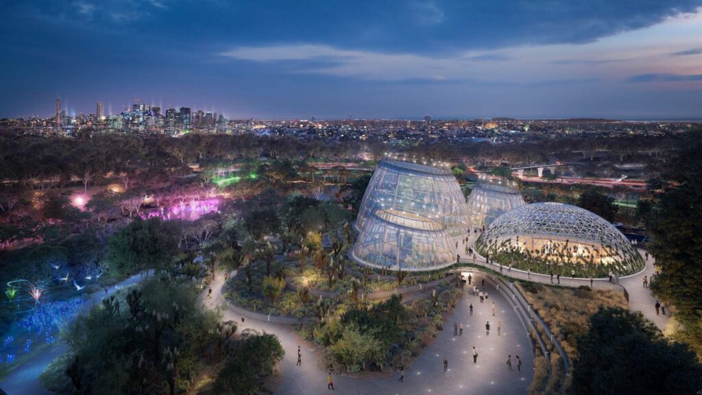 Architectural rendering showing the full Tropical Dome precinct at night, featuring illuminated walkways and Brisbane skyline views.