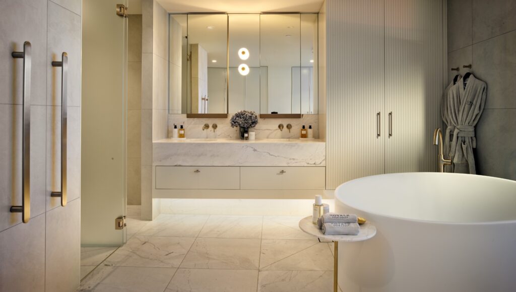 Interior image of a luxury ensuite featuring a freestanding bath, marble finishes and coastal outlook.