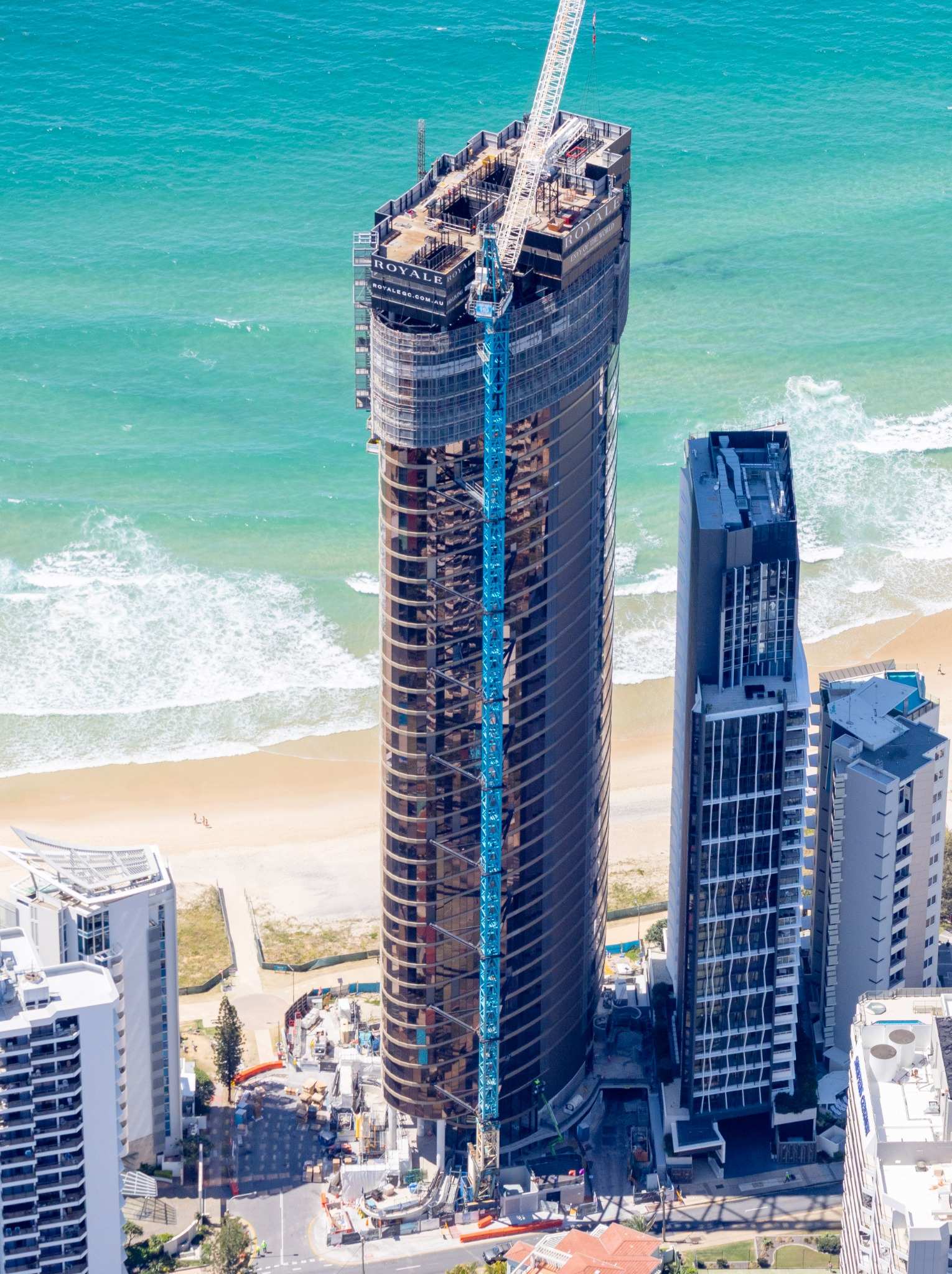 Aerial photograph of Royale Gold Coast viewed from the west, highlighting progress on upper-level construction and proximity to the beachfront.