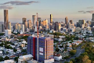 The topped-out Oria tower stands 15 storeys above Spring Hill, framed against the Brisbane CBD. Image supplied by Keylin.